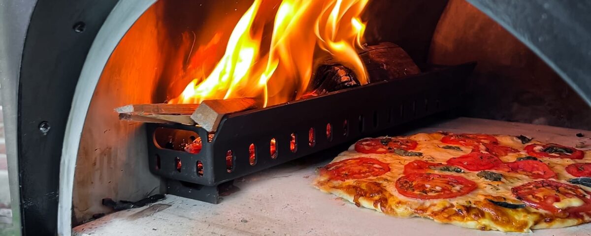 IMG 20250426 WA0009 1 Pizza assando em forno a lenha com chamas visíveis.